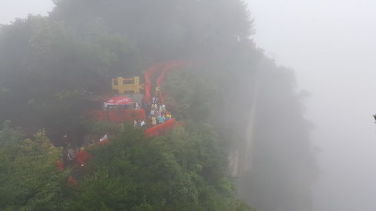 Das Gebäude steht oben auf der Naturbrücke. Das Geländer ist voll mit roten Bändern, die man kaufen und dann anbinden kann
