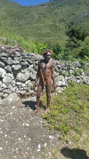 Kanak verschwindet kurz und kommt mit dem Herrn wieder, der einen traditionellen Penisköcher trägt