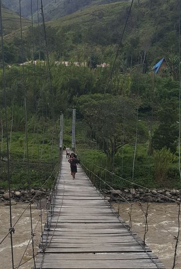 Viele Bretter sind schon durchgebrochen und man kann in die Tiefe auf den reißenden Fluß schauen. Ich halte mich krampfhaft an den Seilen fest..