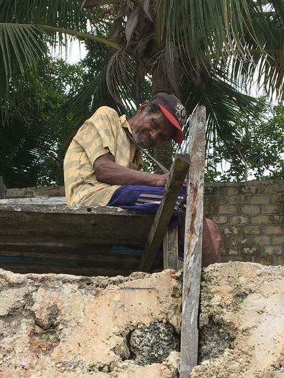 Ein alter Mann entspannt in der Mittagszeit auf seiner am Strand errichteten Terrasse