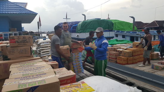 Hier werden schwere Kisten verladen, indem einer sie den anderen zuwirft...