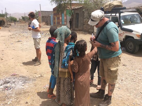 ....Dirk malt „Tattoos“ auf die Arme der Kinder....