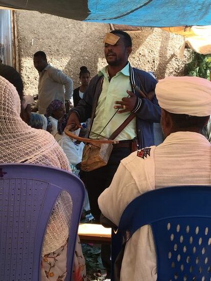 Einer klebt ihm einen Geldschein auf die Stirn...