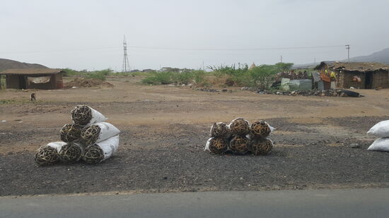 Gebündelte Holzkohle steht zum Verkauf am Straßenrand....
