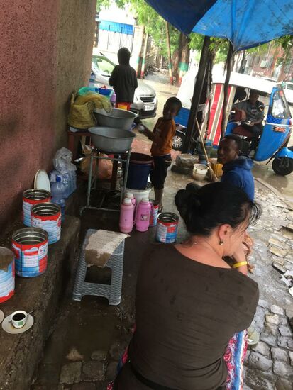 An einem Straßenstand trinken wir 2 Kaffee. Wie auf Kuba, gibt es das gute Getränk für ca 10 Cent mit reichlich Zucker aus der Thermoskanne. Der kleine Junge—(ca 8 Jahre) wäscht die ganze Zeit Tassen in einem Eimer ab.
Das Geschäft läuft gut—hier stoppen viele—überwiegend auch die Tuk-Tuk-Fahrer.
Als Sitzplätze dienen Blechdosen mit Pappe als Sitzpolster