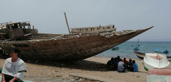 Christine mit Schiff—-überall lungern die Menschen gelangweilt herum—hier am Strand...