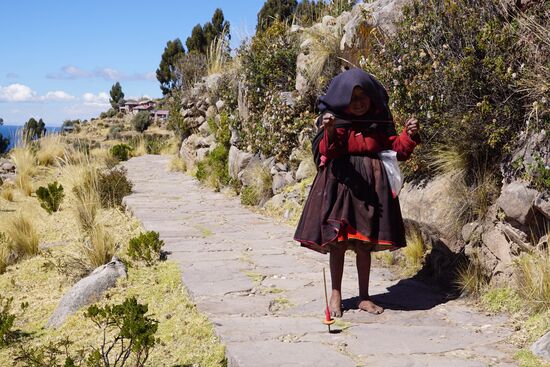 Um 10 Uhr gehts weiter über die Insel—zu Fuß für uns. Hier treffen wir eine Oma, die währen sie geht am stricken oder spindeln ist.