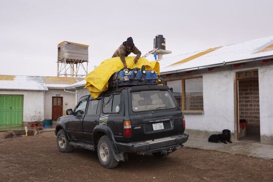 Richard schnürt unsere Rucksäcke auf dem Dach des Jeeps fest.