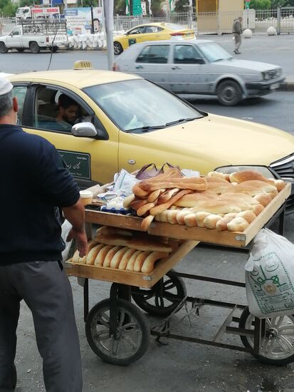 Ein Bäcker baut seinen Stand am Straßenrand auf...und schon hält ein Taxifahrer an, um sich an der frischen Ware zu bedienen.