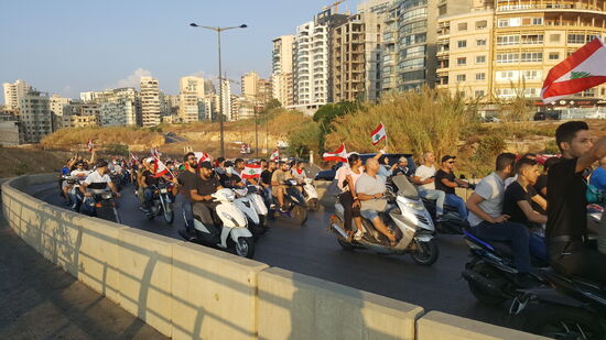 Und da kommt sie: eine Parade—oder Flotte von Jeeps, Motorrädern und Fahrzeugen jeglicher Art. Jubelnd, schreiend, hupend und die libanesische Flagge schwenkend.