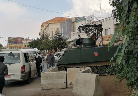 Einer der vielen bemannten Panzer. Wir sehen auch Wälle aus Sandsäcken, in denen Soldaten hocken. Der ganze Ort kommt einem vor wie ein Kriegsschauplatz, der gerade den Atem anhält—aber jederzeit wieder aktiv werden kann.