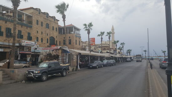 Die Hafenstraße. Hinten eine große Moschee—und vorne viele Hafenrestaurants unter Zeltplanen....viel Leute sehen wir nicht.