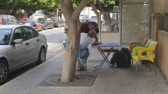 Dirk vertreibt sich die Zeit mit dem Mann, der uns vorher eine der hier üblichen Süßcreme im Brötchen verkauft hat—eine leckere Spezialität!