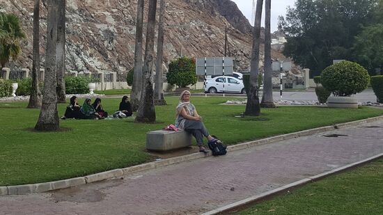 Claudia auf der Bank und im Hintergrund eine omanische Frauengruppe auf der Decke