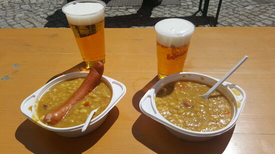 Oben ist es frisch und wie immer windig. Traditionell gibt es Erbsensuppe und ein Bierchen. Wir nehmen es im Außenbereich zu uns, denn am Eingang des Restaurants befindet sich eine lange Warteschlange