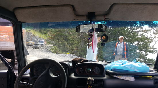 Bald wechselt die Straße in eine Schotterpiste und öfter müssen wir stoppen, wenn Baufahrzeuge den Weg versperren