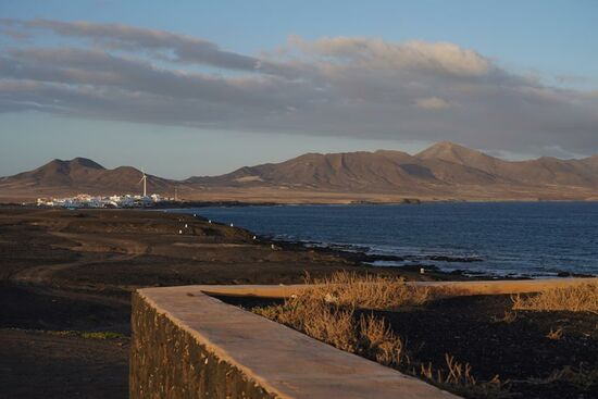 Abends fährt Thomas noch einmal hierher um Fotos bei Sonnenuntergang zu machen. Hier ist er am Leuchtturm  „Faro de Punta Jandia“ -an dem wir gestern waren--und schaut auf ein kleines Dörfchen von Campern