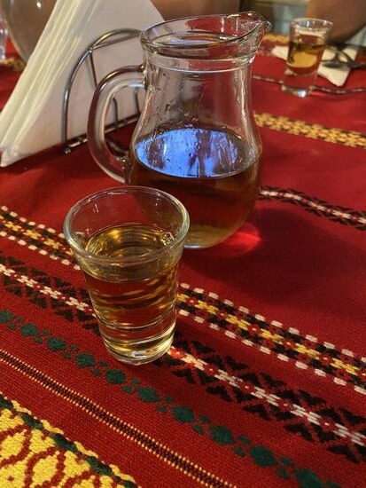 Hier gibt es den selbstgebrannten aus Karaffen. Sobald wir sitzen schenkt die Chefin großzügig ein und stößt mit jedem Gast an—das wird wohl ein lustiger Abend!