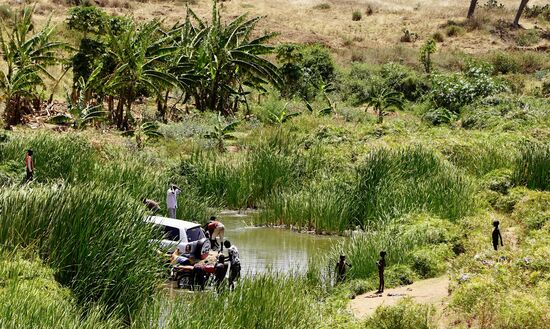 Auch in Uganda scheint das Auto das wichtigste im Leben der Männer zu sein—auf der anderen Seite des Flusses wird es gewaschen