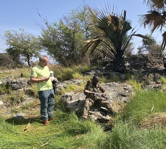 Sehr umständlich hantiert James mit seiner Kalaschnikow und schöpft mit seinem Barrett „heißes“. Wasser. Es ist aber nur nur lauwarm. Die heißen Quellen sind durch vulkanische Aktivitäten weiter im Westen entstanden. Auch sie leiden unter der Dürre.