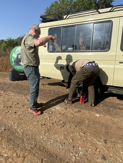 Denis macht sich ans Werk und holt den „Jack“ (Wagenheber). Thomas versucht ihm Schatten zu spenden und macht den Adler. 