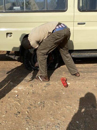 Das Ganze ist nicht so einfach, da: der Untergrund sehr uneben ist, der Metallstab für den Jack im Fahrzeug fehlt und weil Denis den Wagenheber an der falschen Position angesetzt hat.