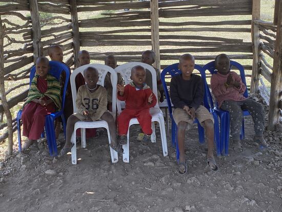 Wir werden noch zum Kindergarten/Schule geführt. Die Regierung fordert die Massai auf, die Kinder in die Schule zu schicken. Doch nicht alle können auf die öffentliche oder gar private Schulen gehen. Deshalb unterrichtet eine eigene Lehrerin aus der Familie alle Kinder.
Wir befinden uns hier im Klassenraum