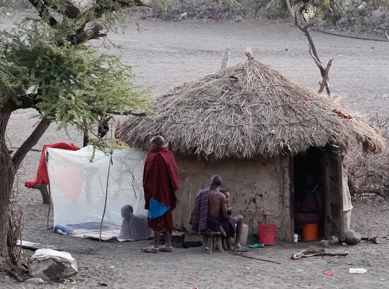 Hier eine Massai Familie beim Frühstück. Wie man sieht, schlafen die Kinder draußen vor der Hütte - geschützt mit einem Moskitonetz