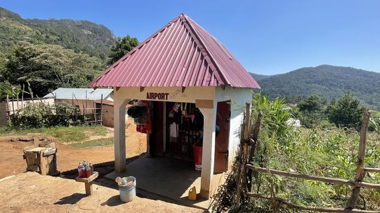 Airport? Wohin? Man beachte die Flaschen mit Flüssigkeit vor dem Airport. Hierbei handelt es sich um Benzin für die Mopeds/Motorräder. Abgabe in Kleinstmengen. Der Weg zur nächsten Tankstelle ist sehr weit.