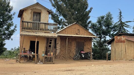 Zwei Jungs sitzen vor einem Haus und bieten Gemüse an. Viel Kundschaft kommt heute sicherlich nicht.