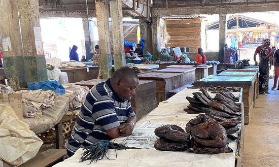 Gelangweilt liest er nebenbei Zeitung. Er muss sich beeilen. Wenn ein Kunde kommt, dann wird der Fisch sicherlich in der Zeitung eingepackt 