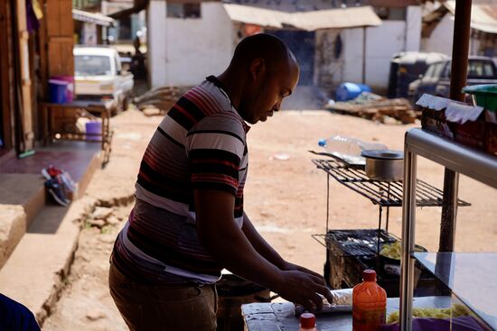 Er bereitet die Pommes zu - hier packt er gerade eine Tortilla sorgfältig ein und wir sehen dann, wie er sie persönlich ausliefern geht - er geht über den Platz und verschwindet in der Menge. Kurze Zeit später ist er schon wieder zurück und steht wieder am Herd.