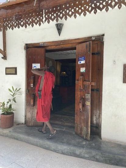 Der Eingang unserer Unterkunft—der Massai gehört zum Team, er trägt uns die Koffer hinauf. Kaum zu glauben, dass sich hinter diesem schlichten Eingang ein so tolles Hotel befindet.