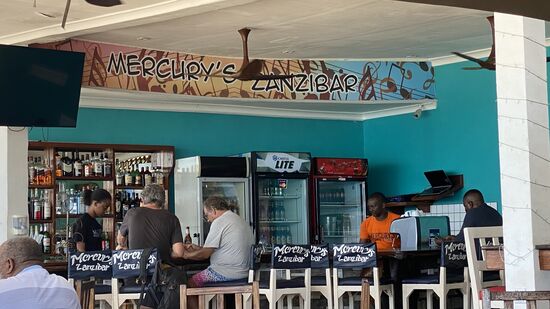 Wir besuchen „Mercury`s Zanzibar“ -eine angesagte Location und Pizzeria.
Viele Restaurants werben mit dem Namen von Freddie Mercury. Und bei vielen Häusern wird behauptet, Freddie sei dort geboren und habe dort gelebt. Wo genau er geboren ist und gelebt hat in Stonetown, ist nicht bekannt. Aber die ersten Lebensjahre hat er auf Sansibar verbracht.