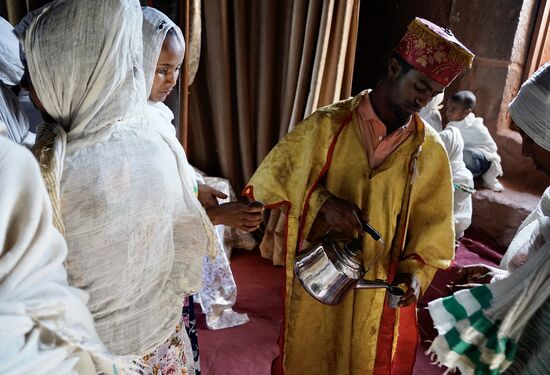 … und verteilt „Holy Water“ in kleinen Bechern und die Gläubigen trinken es.
