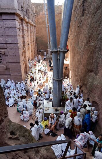Hier vor dieser Kirche haben sich sehr viele Gläubige versammelt. Man betet gemeinsam mit dem Priester. In die Kirche würden die Personen gar nicht alle hinein passen.