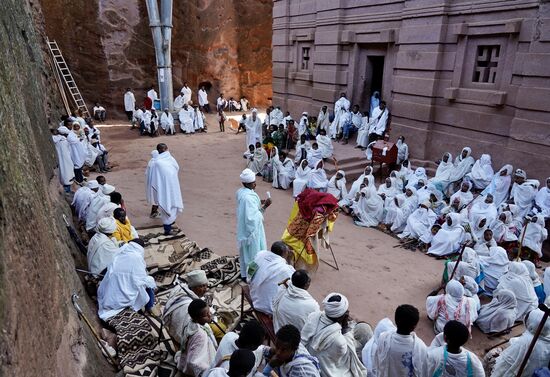 Ein Priester betet vor und alle reihen sich in das Gebet ein. Vor ihm sind Gewänder zu sehen. Später gehen alle Gläubigen zum Priester, der dann die Gewänder hält, und küssen diese.