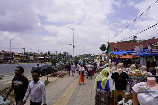 Wir fahren zurück in die Stadt. Auf dem Wege halten wir an einigen Läden, in denen Kleidung aus Leinen feilgeboten wird. Viele der Händler kommen aus Goma. Alex erkennt das an den Mustern der Kleidung. Er selbst kommt auch dort her.