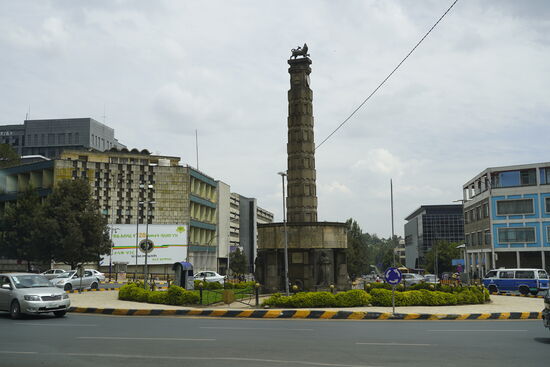 Dieses Monument wurde anlässlich der Unabhängigkeit Äthiopiens aufgestellt. Nach dem 2. Weltkrieg befreite sich Äthiopien aus der faschistischen Herschafft Italiens und Kaiser Haile Selassie führte Äthiopien in die Unabhängkeit. Der sozialistische Militärputsch von 1974 läutete dann eine der repressivsten Diktaturen Afrikas ein, die 1991 durch einen Bürgerkrieg niedergeschlagen wurde.
Äthiopien gilt zwar als Demokratie, aber die Unruhen in den verschiedenen Regionen und Konflikte bestehen weiter. 1993 löste sich nach einem Bürgerkrieg die Region Eritrea und würde selbständig. Doch die Konflikte hinsichtlich Gebietszuordnungen endeten nie. Äthiopien hat bis heute die umstrittenen Gebiete nicht zu Eritrea gehörend anerkannt. Die Volksbefreiungsfront Tigre (TPLF) hat in den letzten Monaten die Kriegshandlungen wieder aufleben lassen und es kommt immer wieder zu Übergriffen und Tötungen in den nördlichen Regionen Äthiopiens. Trotz aller Bemühungen gilt Äthiopien als instabiler Staat.
Die TPLF hat im September 2020 in der Tigris Region eigene Wahlen ausgerufen und wollte sich von der Zentralregierung und Addis lossagen. Die Tigris machen ca. 10% der Bevölkerung aus. Und sie waren knapp 30 Jahre an der Regierung.
Die Tigris werden finanziell und mit Waffen von den USA unterstützt. Die Regierung in Addis ist teilweise tatenlos in den Überfällen, die im Norden des Landes toben und deren Schäden wir selbst in Lalibela gesehen haben. Russland unterstützt die Zentralregierung. Es ist also nicht nur ein Konflikt im Land selbst, sondern wie in vielen anderen Ländern ein Konflikt USA-Russland.