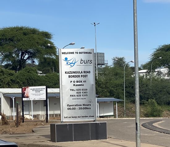 Für uns geht der Grenzübergang dank „Kaza-Visum“ fix—allerdings müssen wir fast eine Stunde auf das indische Ehepaar warten. Gäste mit indischem Pass bekommen kein Kaza-Visum. Warum auch immer—sie mußten nun ein neues für Botswana beantragen und bezahlen. Zu allem Überfluss funktionierte die Kreditkarte nicht und deshalb dauerte es so lange. 
Später erfuhren wir, dass der nette Officer seine KK nahm und das Bargeld entgegennahm