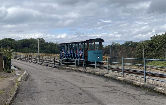 Eine Tram fährt Leute von einer Seite zur anderen