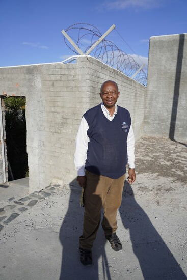 Und das ist Barr. Er nimmt uns in Empfang und wird uns auf das Gelände führen und auch die Zellen und weiteren Einrichtungen zeigen.
Barr erzählt uns dann, dass er Zeitzeuge ist. Er hat hier selbst 7 Jahre eingesessen. Warum? Weil er sich stark gemacht hat, die Rassentrennung aufzuheben und mit der ANC sympathisiert hat. ANC = African National Congress - führende Bewegung gegen die Apartheit. Von 1960 bis 1990 verboten.