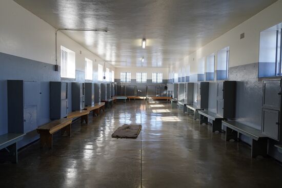 Dieser Raum ist eine der Zellen, in denen die nicht so schwierigen Häftlinge untergebracht waren. 60 Männer waren in dieser Zelle. Es gab einen Waschraum mit 4 Duschen und 2 Toiletten. Geschlafen wurde auf den Kokosmatten. Fensterscheiben gab es keine, im Winter war es hier sehr kalt.