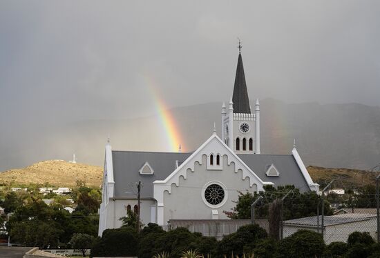 Die süße niederländische Ortskirche mit einem wunderschönen Regenbogen