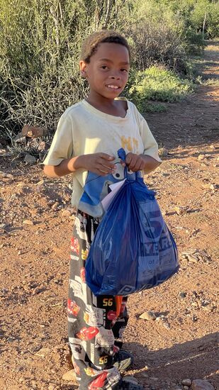 Er freut sich über die Tüte voll Sachen für sich und seine Familie.