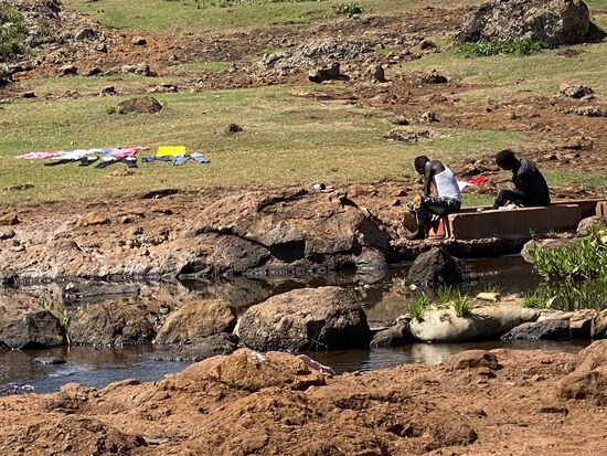 Ein paar Jungs waschen Wäsche und legen sie zum trocknen in die Sonne
