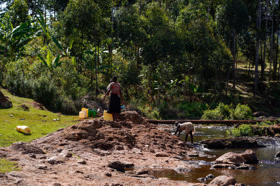 Frauen befüllen große Kanister mit Wasser….
