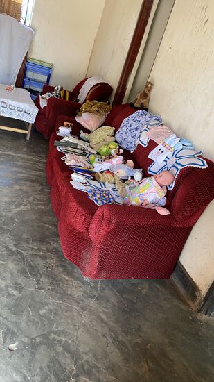 Wir fangen an, die zwei Koffer Kleiderspenden und Spielsachen in einer der Hütten auszupacken