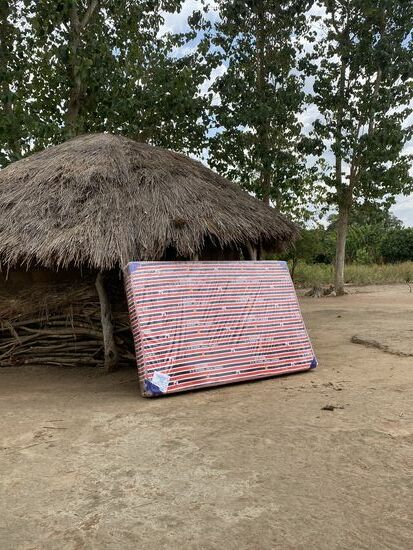 Dies ist das Haus von Dominique. Wir müssen die Matratze biegen, sonst passt sie nicht durch den Eingang.