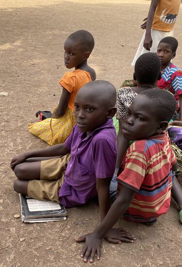 Viele Kinder kamen direkt nach der Schule zum Platz und haben viele Stunden auf uns  gewartet. Er hat seine Schulsachen dabei…